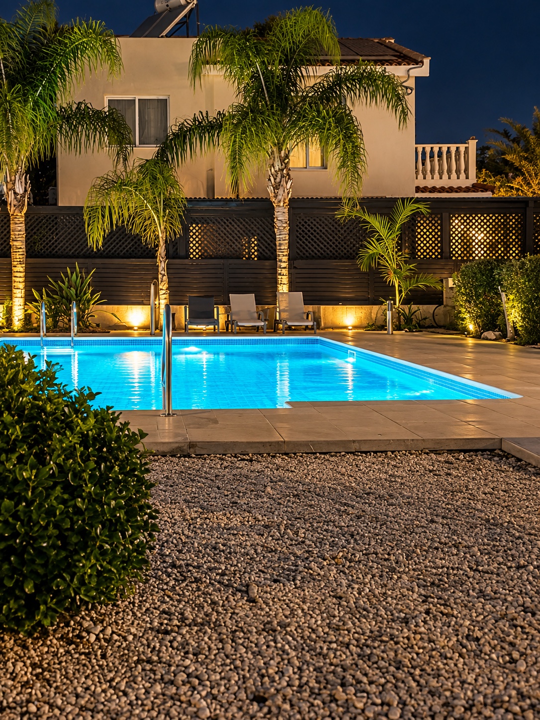 Illuminated swimming pool and landscaped residential property at Universe 4 in Pafos